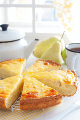 Pie from curd pastry with pear and sour cream, cut into pieces, selective focus