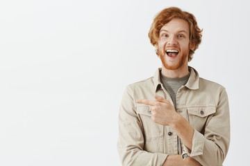 Waist-up shot of uplifted good-looking curious and happy redhead guy with beard and wavy hair in...