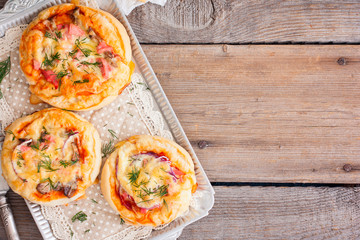 Mini pizza with sausage, top view, horizontal, copy space