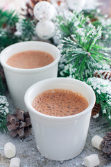 two glasses with hot chocolate in Christmas decorations, selective focus