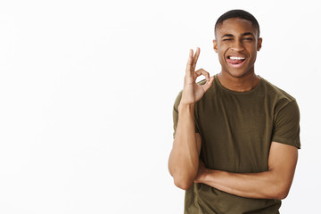 Charming flirty and confident young handsome male model sticking out tongue playful winking at...