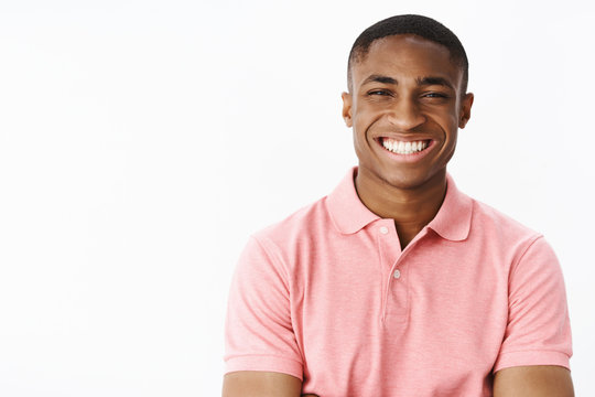Portrait of charismatic pleasant and happy attractive young african american male in pink polo-shirt laughing, smiling joyfully making friendly and excited expression having good time in great company