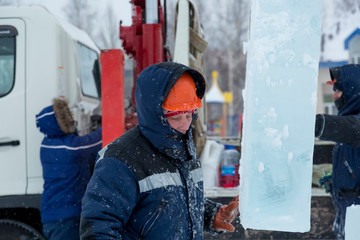 Portrait of an assembler in an orange helmet with a hood