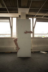 A man leg and hand behind broken door