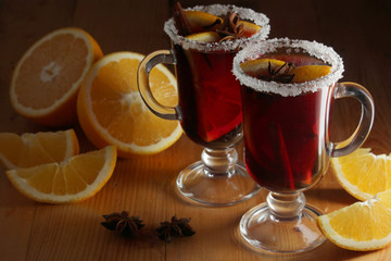 Two cups with ready mulled wine with anise, cinnamon and nuts around