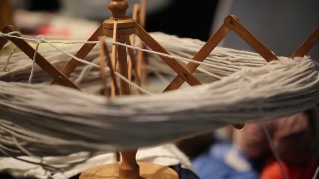 wooden spinning wheel turns to create a skein of wool for the artisan tailoring