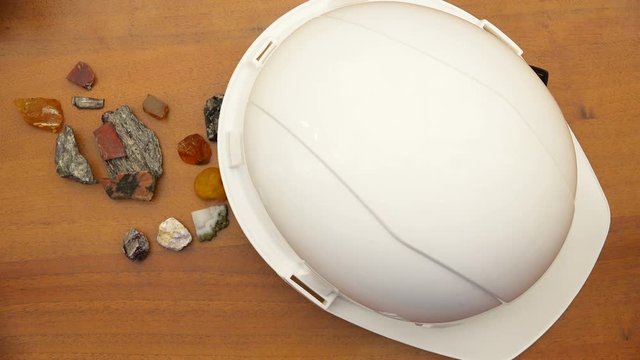 Natural stones and a construction helmet are on the table.