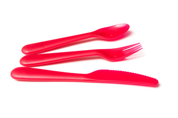 set of red baby plastic spoon, fork and knife on white background