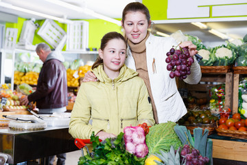 Girl and woman looking for fruits during family shopping