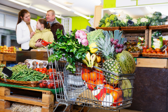 Full shopping cart in vegetables store