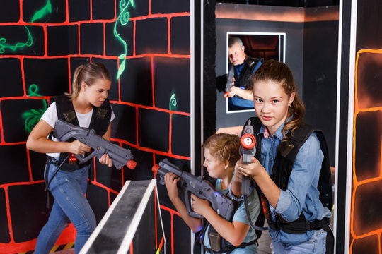 Teen girl with laser pistol on dark labyrinth