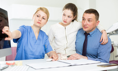 Fototapeta premium Female dentist explaining X-ray to patients