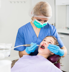 Female dentist treating girl