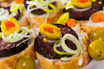 Canapes with blood sausage and olives