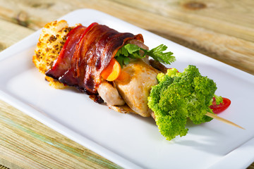 Roasted quail wrapped in ham with vegetables