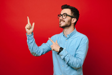 Crazy smiling young man is pointing to up