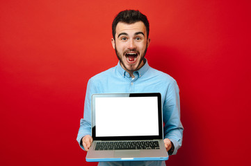 Photo of young man who is shocked about his new laptop