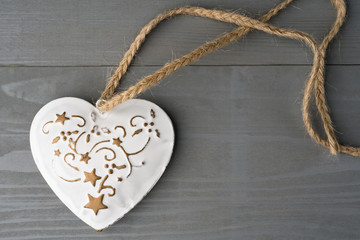 Festive heart shaped Christmas or New Year ornament with twine. Grey background. Copy space on the right.