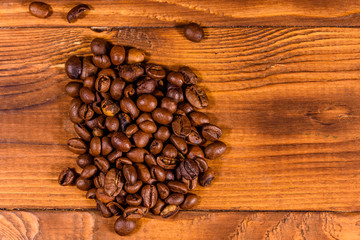 Pile of the coffee beans on wooden table. Top view