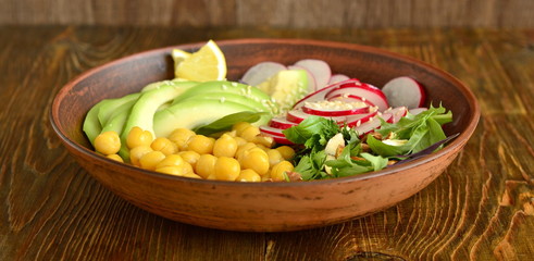 Vegetarian bowl with chickpeas, radish, avocado, herb and seeds,  salad