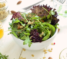 Mix leaves of organic green salad with nuts, oat flakes and seeds