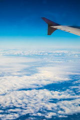 Fototapeta na wymiar Left airplane wing on a blue cloudscape view