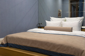 Hotel king size bed on a blue wall and big mirror