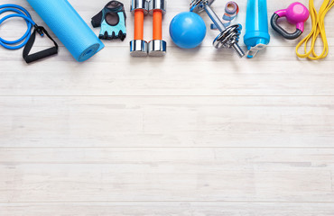 Sports equipment on a white wooden background. Top view. Motivation