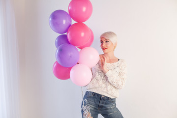 Fototapeta na wymiar blonde woman with balloons and gift for holiday
