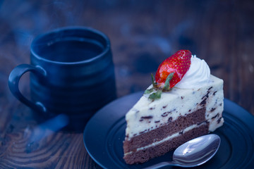 Steaming hot coffee and chocolate and cheese cake on wood background