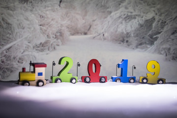 2019 happy new year,wooden toy train carrying numbers and Cristmas tree,covering snow