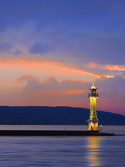 Antique lighthouse at multicolored dramatic sunset, Lake Geneva, Switzerland.