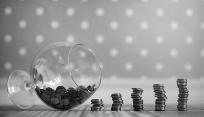 Coins in a jar on the floor. Accumulated coins on the floor. Savings in piles.