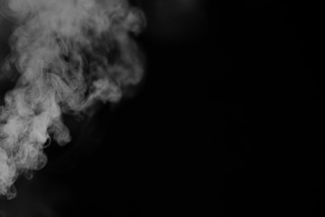 White smoke on a black background. Texture of smoke. Clubs of white smoke on a dark background for an overlay