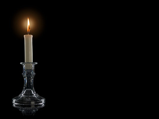 Burning candle in a glass candlestick