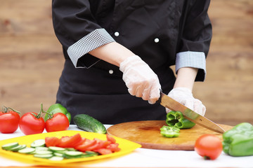 The cook cuts fresh farm vegetables