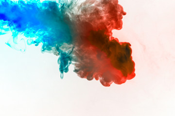 Dynamic puffs of blue gray and orange colors on a white background flow smoothly coloring waves rendering an isolated smoke pattern. Decorative wallpaper with multi-colored smoke.