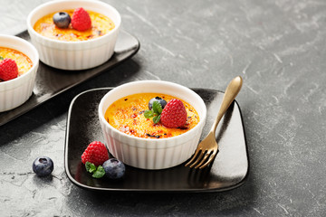 Creme brulee. Traditional French vanilla cream dessert with caramelised sugar on top and fresh berry. - Image