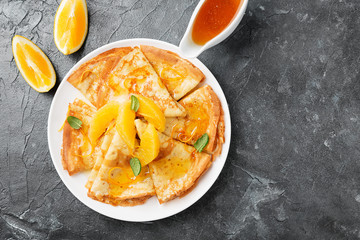 Crepes suzette - pancakes with orange sauce on dark blue background.