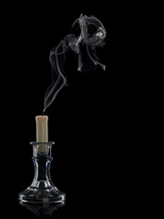The extinguished candle in a glass candlestick