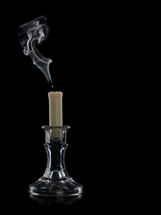 The extinguished candle in a glass candlestick