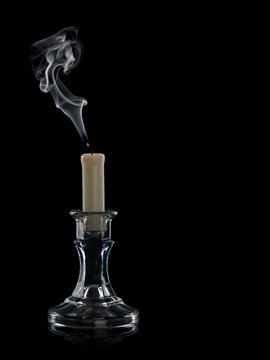 The extinguished candle in a glass candlestick