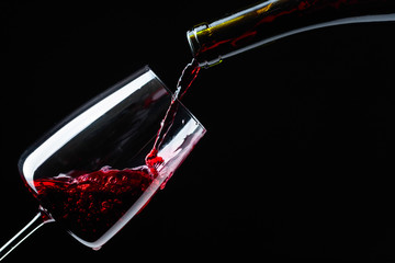 Red wine being poured into wineglass.