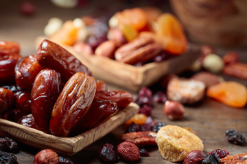 Various dried fruits and nuts in wooden dish.