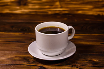 Cup of dark coffee on wooden table