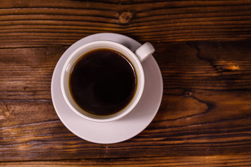 Cup of dark coffee on wooden table. Top view