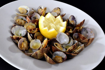 Plato de almejas a la marinera con limón.