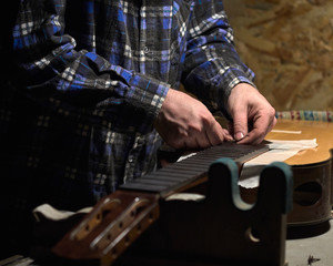 Installation frets on the neck of the guitar.