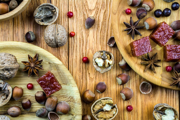 The walnuts and hazelnuts lie in a wooden bowl on the table.