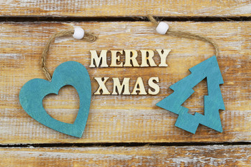 Merry Christmas written with wooden letters and wooden Christmas tree and wooden heart

